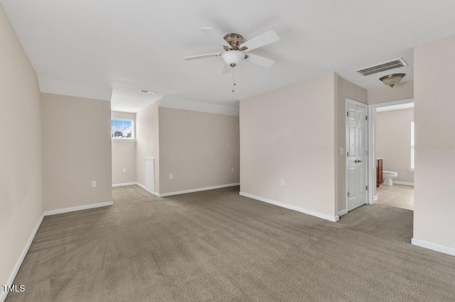 spare room featuring a ceiling fan, carpet, and baseboards