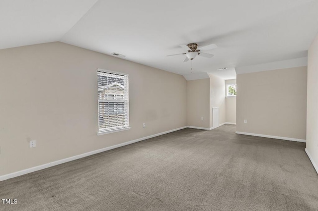 spare room with a ceiling fan, carpet floors, baseboards, and lofted ceiling