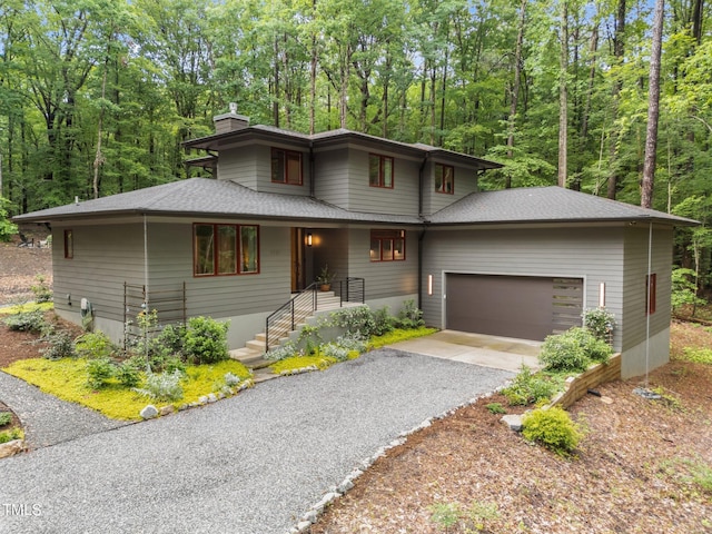 1115 Trailwood Dr, Raleigh, NC 27606 - prairie-style home featuring a chimney, an attached garage, asphalt driveway, and roof with shingles
