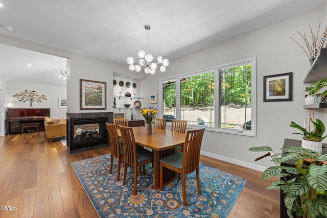 1115 Trailwood Dr, Raleigh, NC 27606 - dining space featuring a chandelier, wood finished floors, baseboards, recessed lighting, and a multi sided fireplace