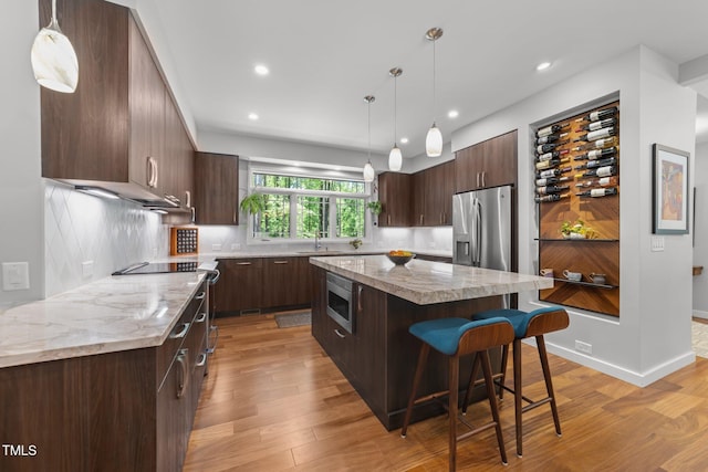1115 Trailwood Dr, Raleigh, NC 27606 - kitchen featuring appliances with stainless steel finishes, modern cabinets, dark brown cabinets, a breakfast bar area, and recessed lighting
