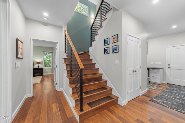 1115 Trailwood Dr, Raleigh, NC 27606 - stairs featuring wood finished floors, baseboards, recessed lighting, and plenty of natural light