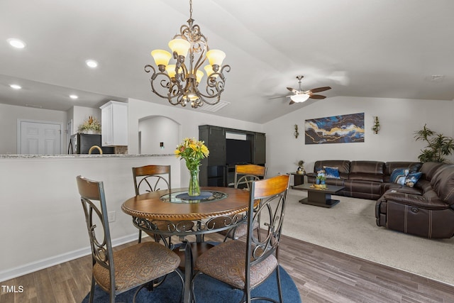 dining area featuring a ceiling fan, lofted ceiling, wood finished floors, a chandelier, and recessed lighting