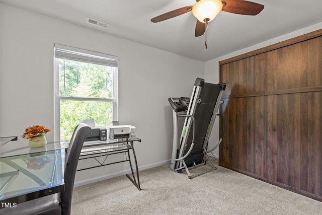 home office with light colored carpet, a ceiling fan, and baseboards