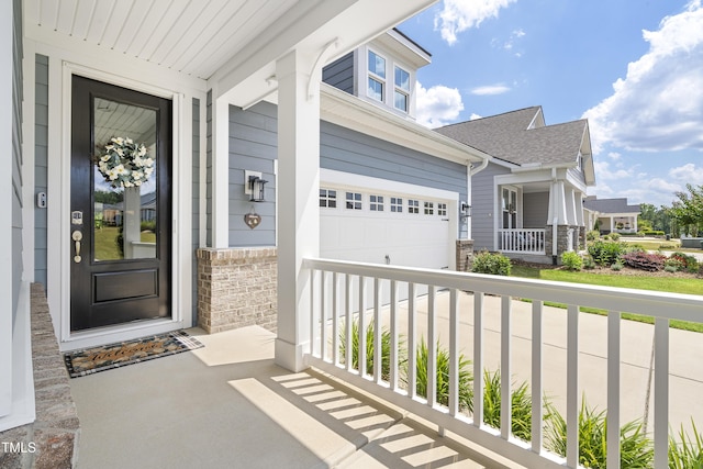 entrance to property featuring covered porch, stone siding, a shingled roof, and a garage
