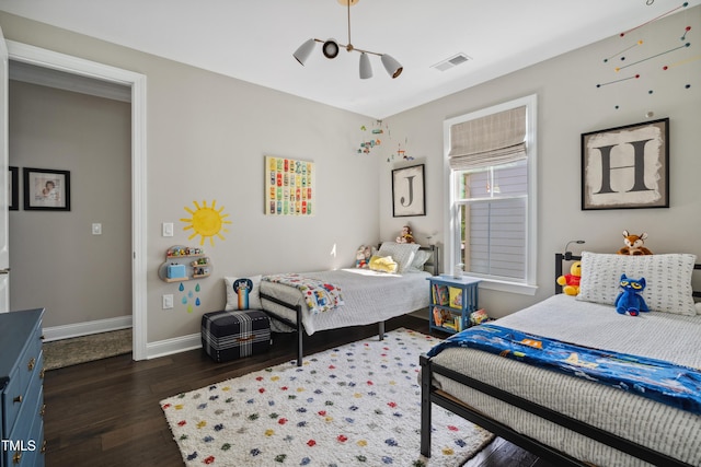 bedroom with dark wood-type flooring and baseboards