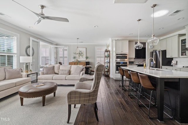 living room featuring dark wood-type flooring, a ceiling fan, crown molding, and recessed lighting