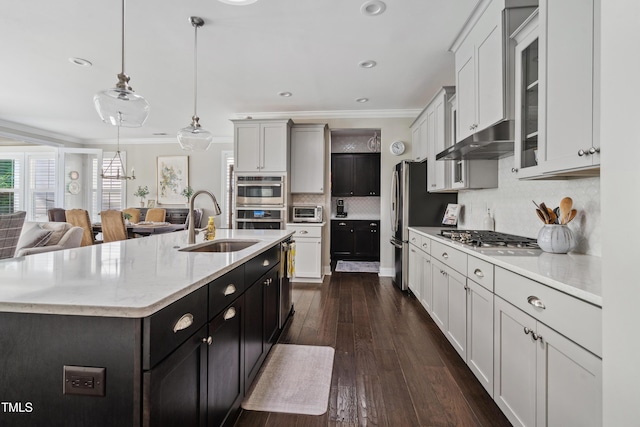 kitchen featuring a sink, appliances with stainless steel finishes, crown molding, backsplash, and glass insert cabinets