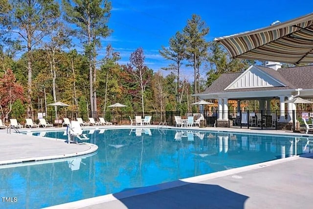community pool with fence and a patio