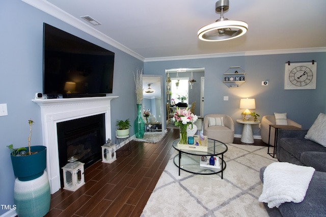 living area with wood finished floors, ornamental molding, baseboards, and a fireplace