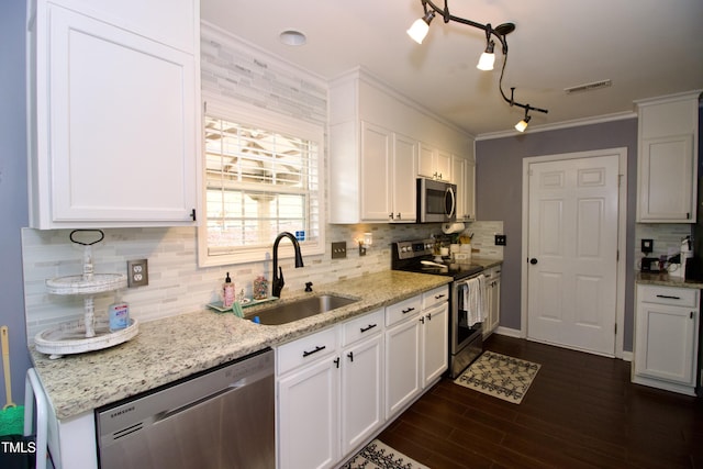kitchen featuring stainless steel appliances, a sink, tasteful backsplash, white cabinets, and crown molding