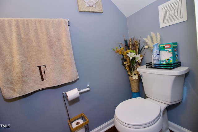 bathroom featuring vaulted ceiling, toilet, and baseboards