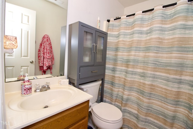 bathroom featuring toilet, vanity, and a shower with shower curtain