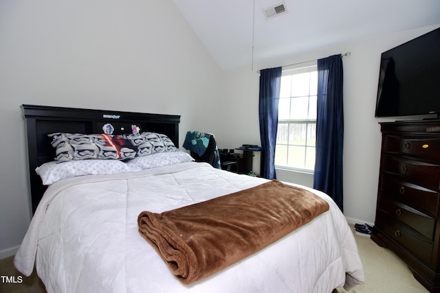 bedroom with light colored carpet, vaulted ceiling, and baseboards