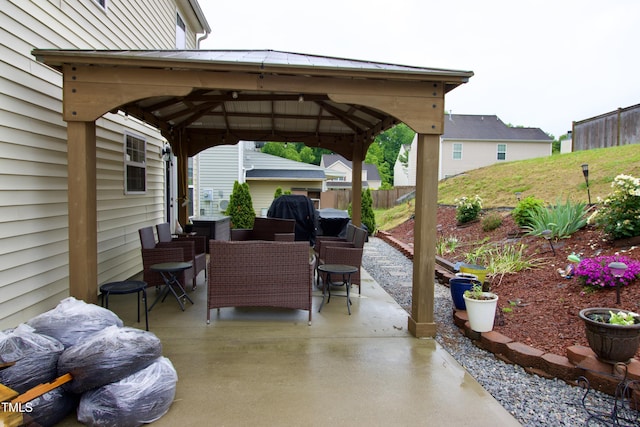 view of patio featuring a gazebo, outdoor dining space, and fence