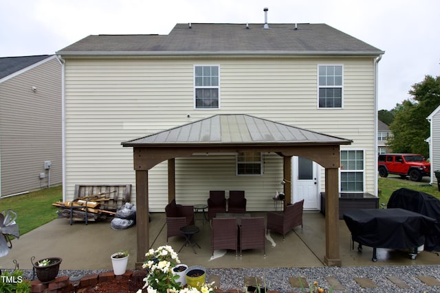 rear view of property featuring a gazebo, a standing seam roof, a patio, and metal roof