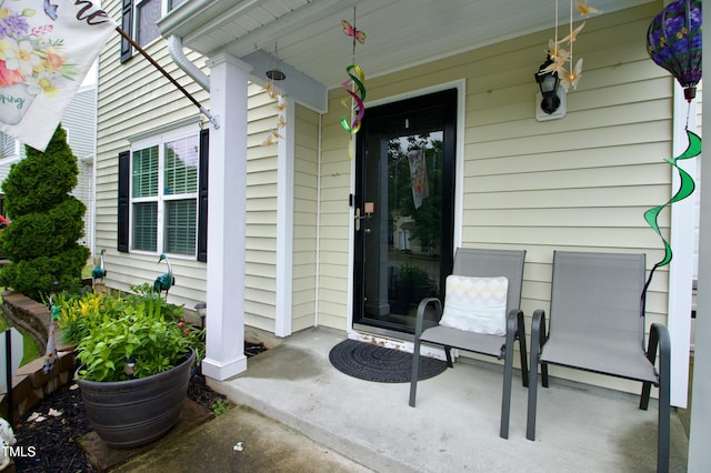 view of exterior entry featuring covered porch