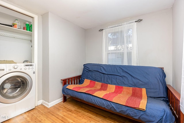 laundry room featuring washer / dryer, wood finished floors, and baseboards