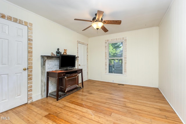living room with light wood-style flooring, ceiling fan, and crown molding