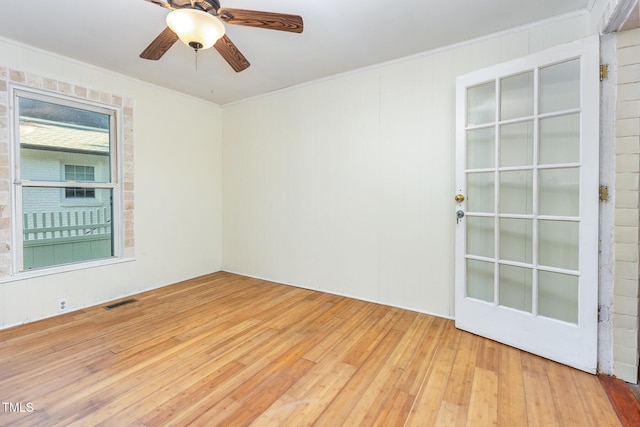 empty room featuring crown molding, light wood finished floors, and ceiling fan