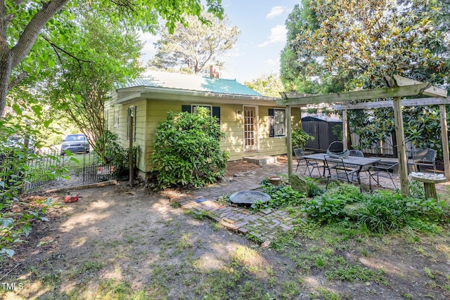 rear view of house with fence, a patio, metal roof, and a pergola