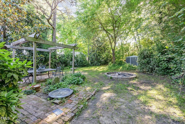 view of yard featuring a fire pit, a patio area, and outdoor dining space