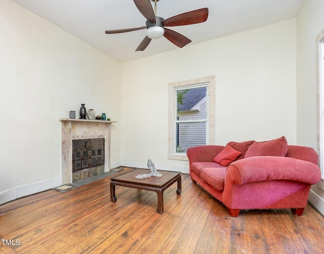 206 N State St, Raleigh, NC 27601 - living room with a tiled fireplace, a ceiling fan, hardwood / wood-style flooring, and baseboards
