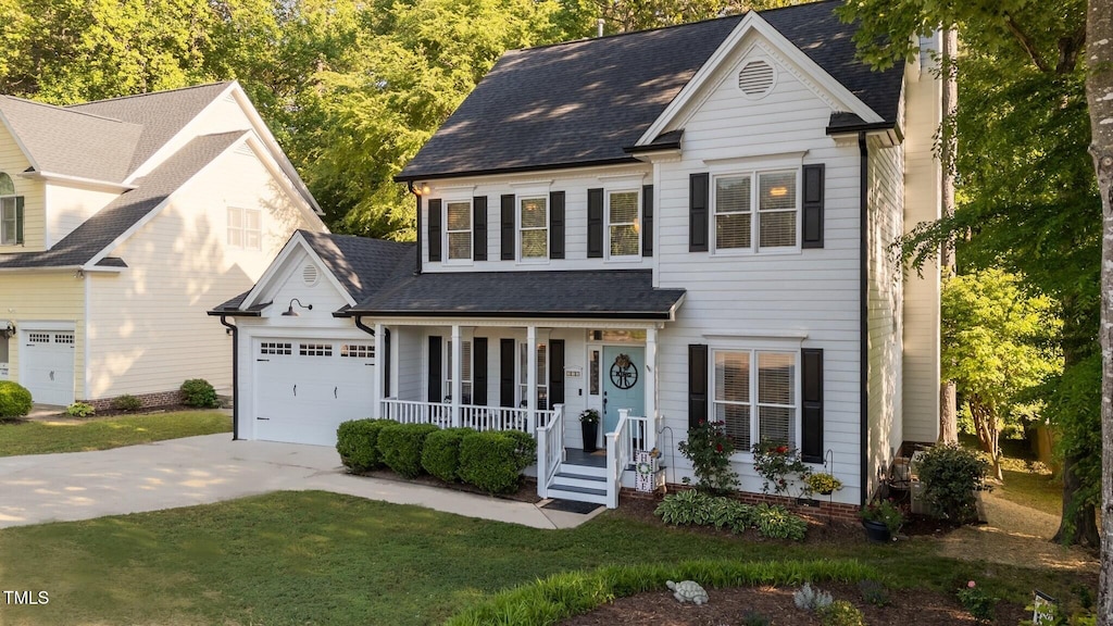 535 W Holding Ave, Wake Forest, NC 27587 - traditional home featuring a porch, driveway, a garage, roof with shingles, and a front lawn