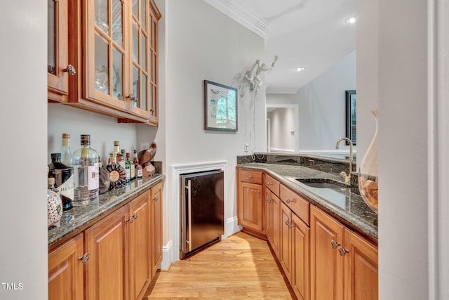 indoor bar featuring crown molding and light wood-style floors