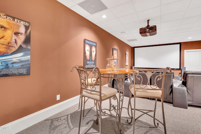 home theater room with carpet, ceiling fan, baseboards, and a drop ceiling