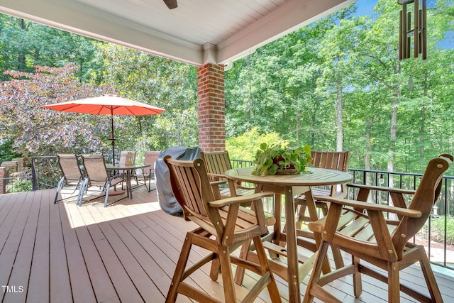 deck with outdoor dining area and a ceiling fan