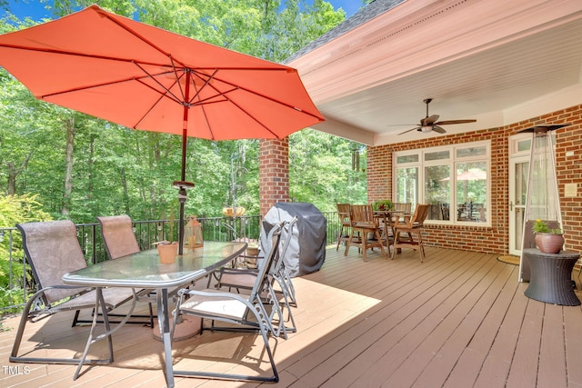deck with outdoor dining space, ceiling fan, and grilling area