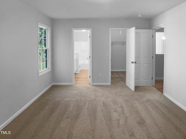 2747 Michelle Ct, Creedmoor, NC 27522 - unfurnished bedroom featuring carpet, baseboards, a walk in closet, ensuite bath, and a closet
