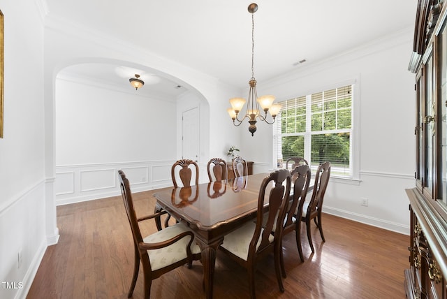 1720 Laurel Park Pl, Cary, NC 27511 - dining area featuring arched walkways, dark wood-type flooring, crown molding, a chandelier, and a wainscoted wall