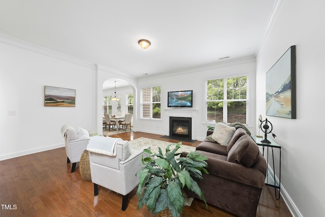 1720 Laurel Park Pl, Cary, NC 27511 - living area with ornamental molding, arched walkways, dark wood-style floors, baseboards, and a fireplace with flush hearth