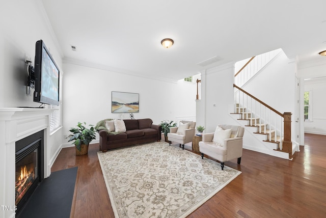 1720 Laurel Park Pl, Cary, NC 27511 - living room with crown molding, a glass covered fireplace, stairs, dark wood-style flooring, and baseboards