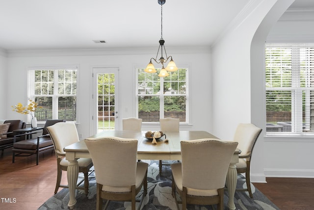 1720 Laurel Park Pl, Cary, NC 27511 - dining space with a chandelier, healthy amount of natural light, crown molding, arched walkways, and dark wood-style flooring