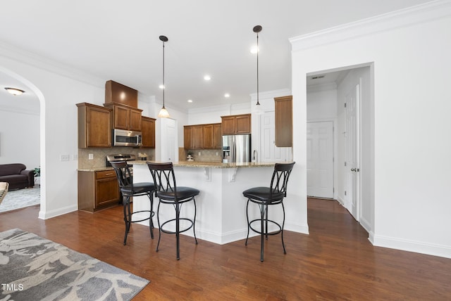 1720 Laurel Park Pl, Cary, NC 27511 - kitchen with appliances with stainless steel finishes, arched walkways, tasteful backsplash, a breakfast bar area, and dark wood-style flooring