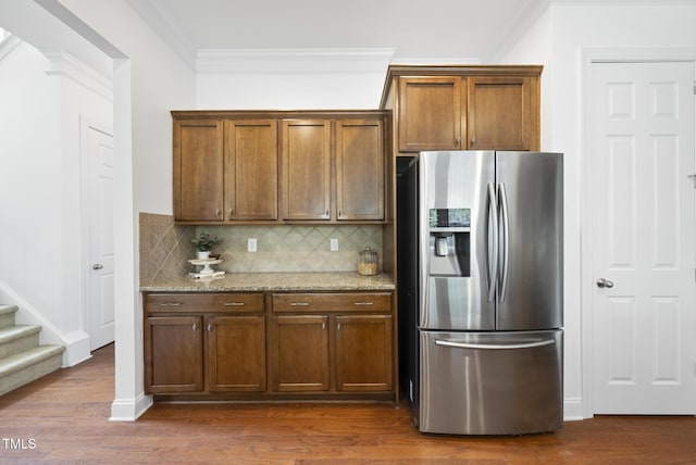 1720 Laurel Park Pl, Cary, NC 27511 - kitchen featuring stainless steel fridge with ice dispenser, ornamental molding, tasteful backsplash, light stone counters, and dark wood finished floors