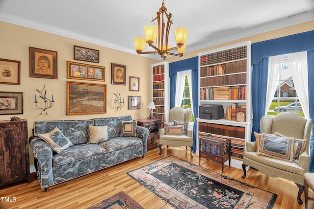 sitting room with a chandelier, crown molding, and wood finished floors