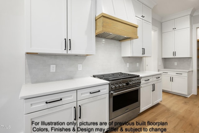 kitchen featuring high end stove, custom range hood, backsplash, white cabinets, and light wood-style floors