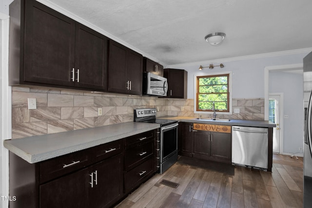5830 Mcdougal Dr, Fayetteville, NC 28304 - kitchen featuring stainless steel appliances, a sink, dark wood finished floors, backsplash, and dark brown cabinets