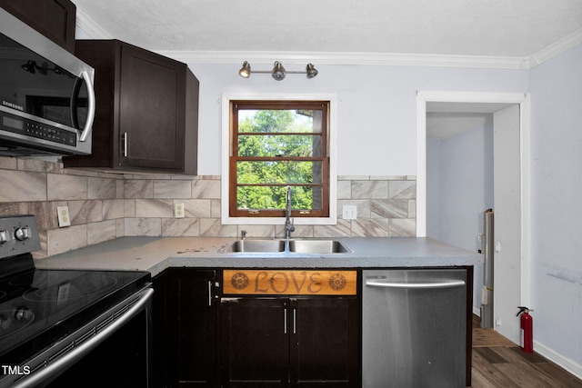 5830 Mcdougal Dr, Fayetteville, NC 28304 - kitchen with stainless steel appliances, a sink, crown molding, dark wood-type flooring, and decorative backsplash