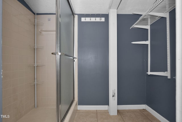 5830 Mcdougal Dr, Fayetteville, NC 28304 - full bath featuring a stall shower, a textured ceiling, tile patterned flooring, and baseboards