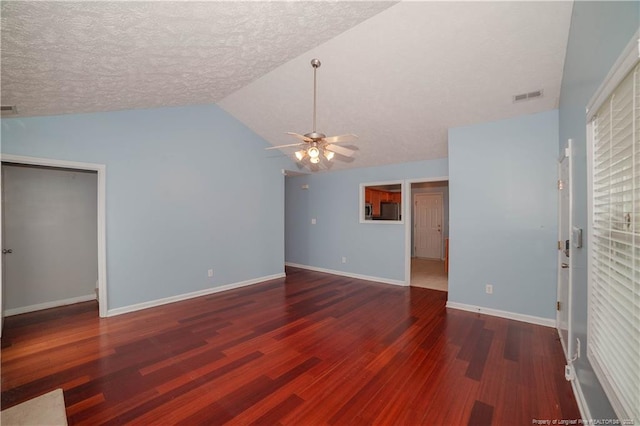 unfurnished living room featuring wood finished floors, a ceiling fan, lofted ceiling, baseboards, and a textured ceiling