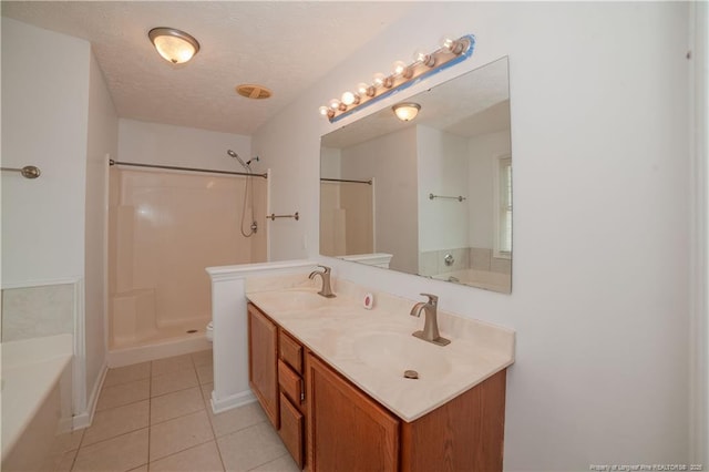 bathroom featuring tile patterned floors, a bathtub, a shower, toilet, and double vanity