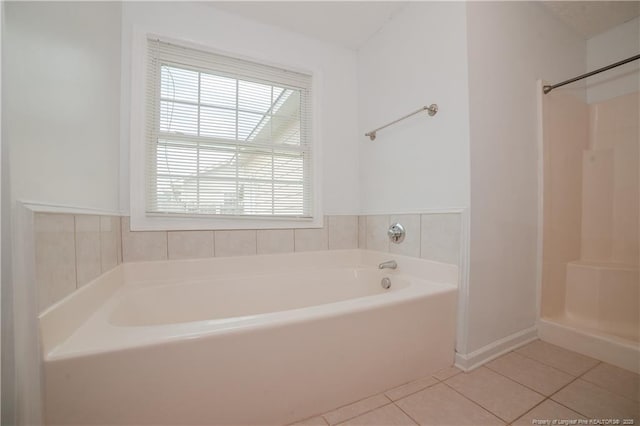 bathroom with tile patterned floors, a garden tub, a walk in shower, and baseboards