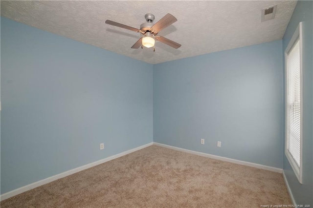 empty room featuring a textured ceiling, ceiling fan, carpet flooring, and baseboards