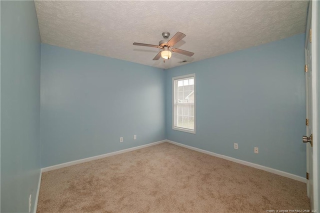 carpeted spare room with a ceiling fan, a textured ceiling, and baseboards