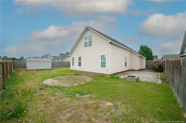 back of house with a shed, an outbuilding, and a patio
